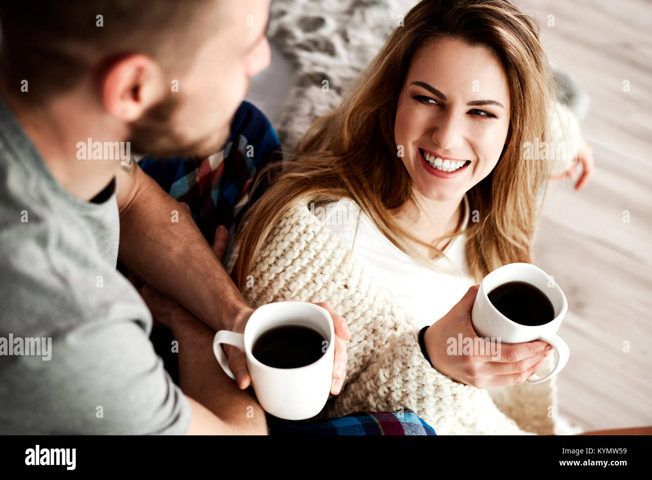 Giovane con caffè parlando in camera da letto Foto Stock