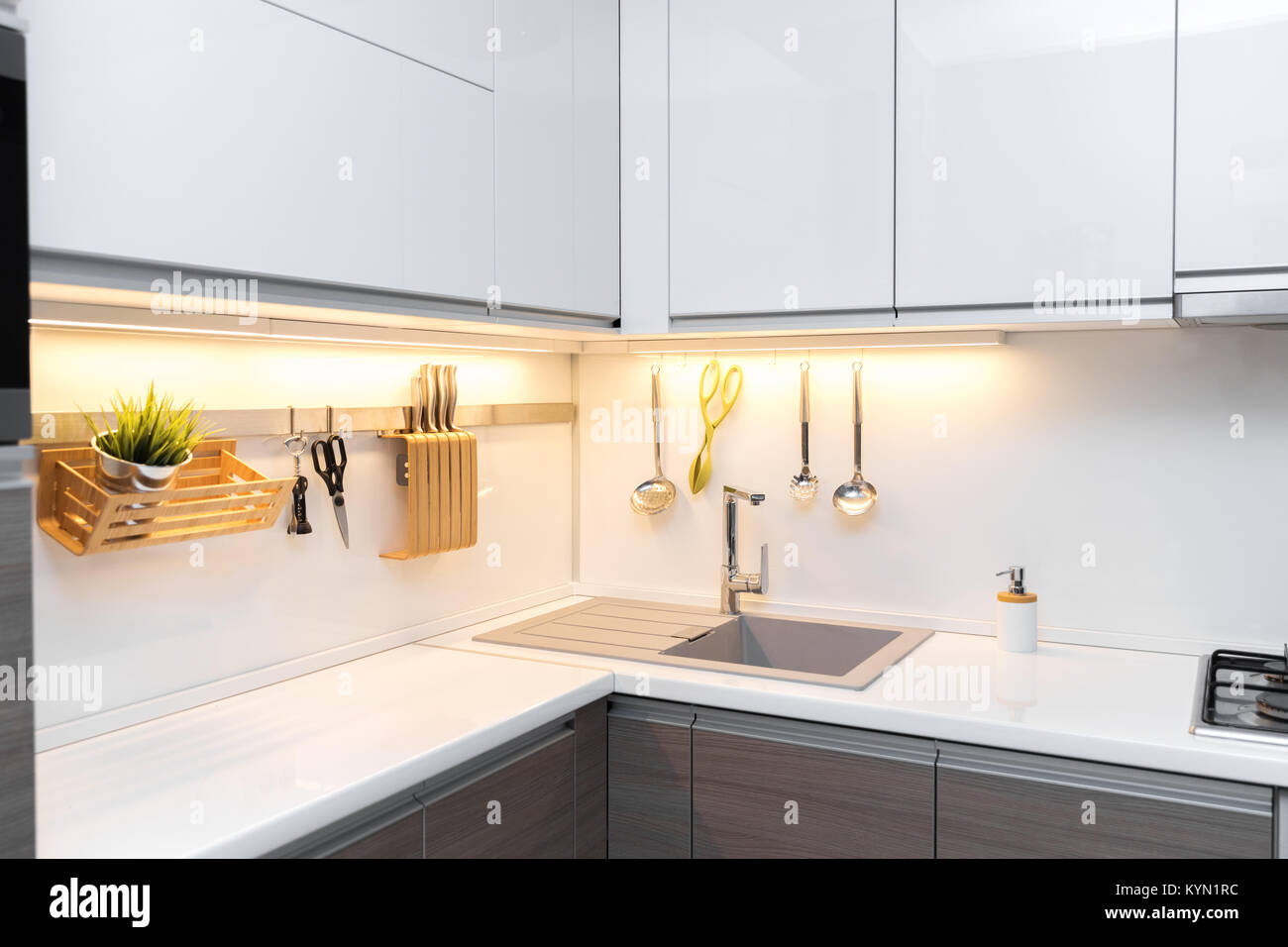 Bianco gloss cucina interni con illuminazione del piano di lavoro Foto Stock