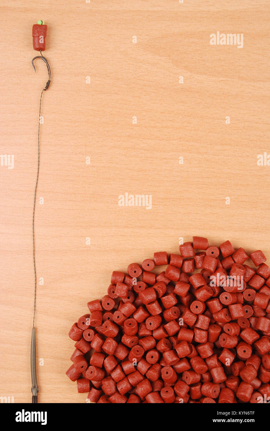 Esche da pesca con gancio e rosso pre-forato halibut pellets per la pesca  alla carpa isolata su uno sfondo di legno con morbida ombra Foto stock -  Alamy