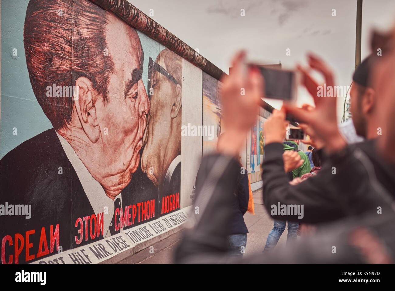 La East Side Gallery di Berlino, Germania, street art graffiti pittura, famoso 'Il Bacio', primo piano fuori fuoco di fotografare turistica Foto Stock