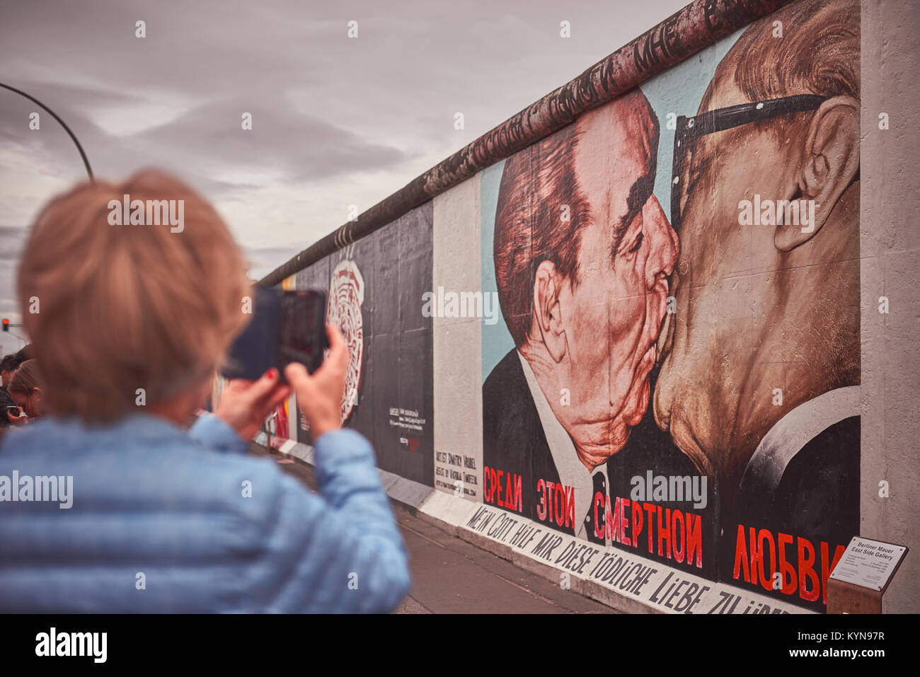 La East Side Gallery di Berlino, Germania, street art graffiti pittura, famoso 'Il Bacio', primo piano fuori fuoco di fotografare turistica Foto Stock