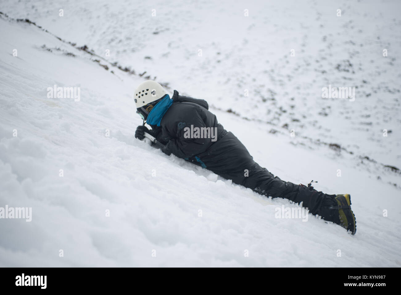 In inverno la formazione di competenze in Cairngorm montagne prima neve viaggio di foratura. Contrassegnare un arresto slitta in montagna con la sua ascia di ghiaccio. Foto Stock