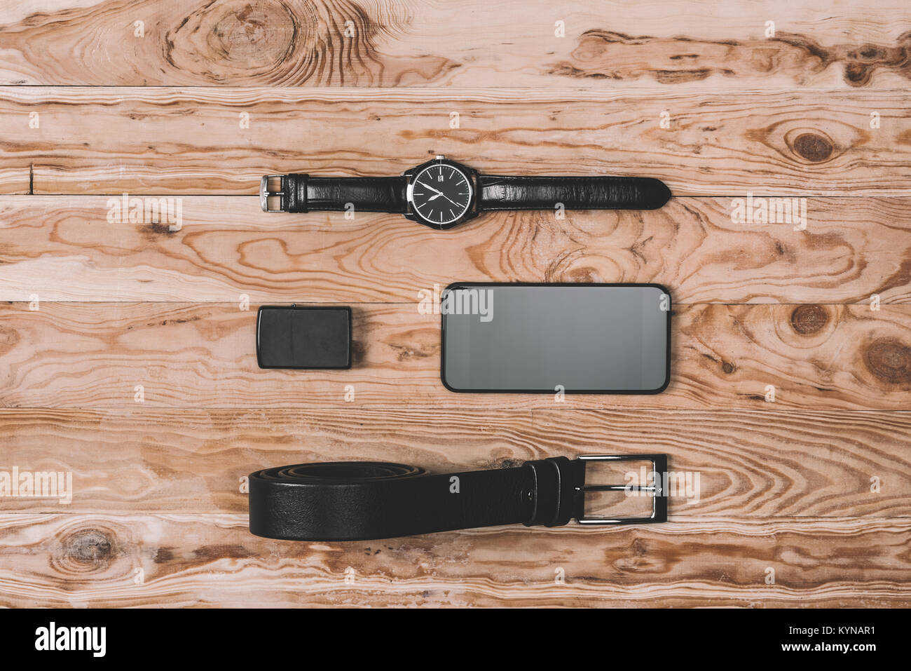 Vista dall'alto di smartphone, cinghia, più leggero e il canto Orologi da tavolo in legno Foto Stock