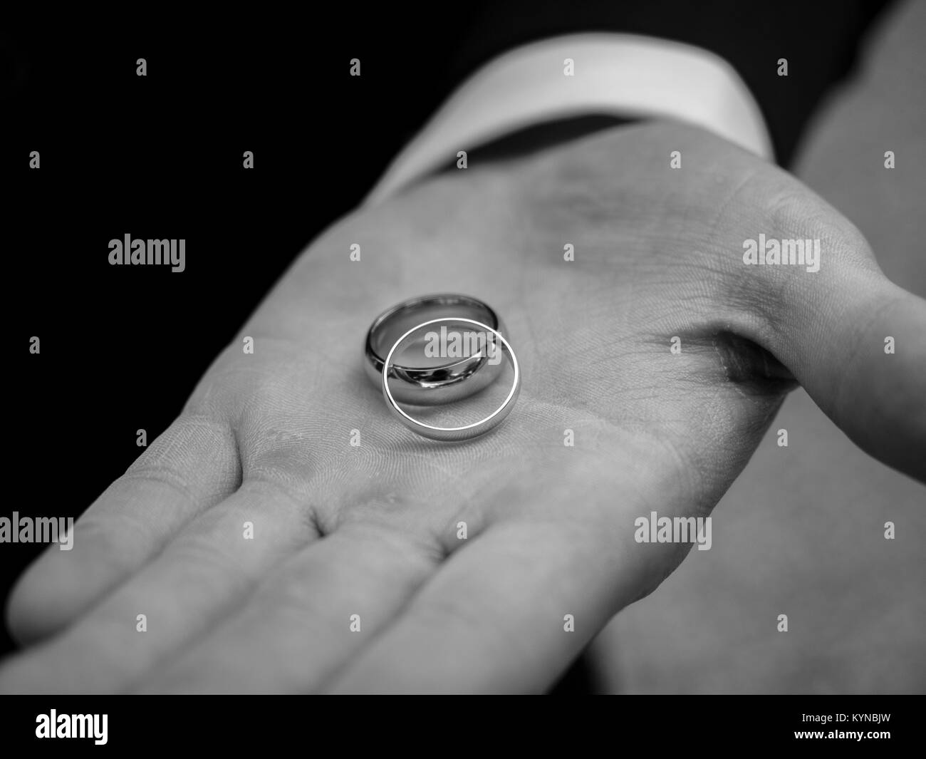 Gli anelli di nozze sposi in mano - fotografia in bianco e nero Foto Stock