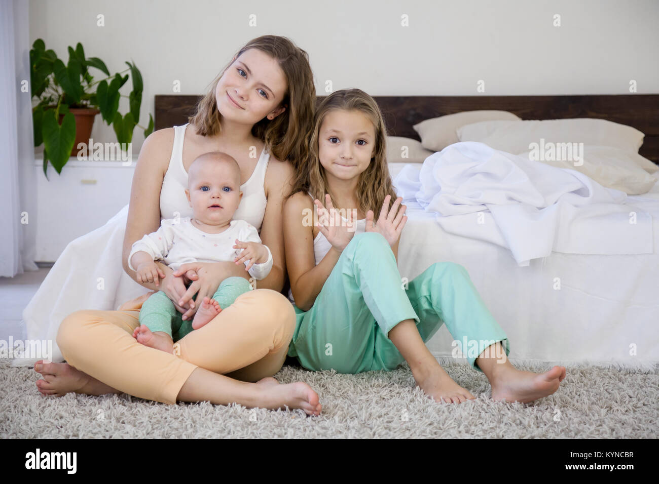 Le tre sorelle giocare i bambini al mattino in camera da letto Foto Stock