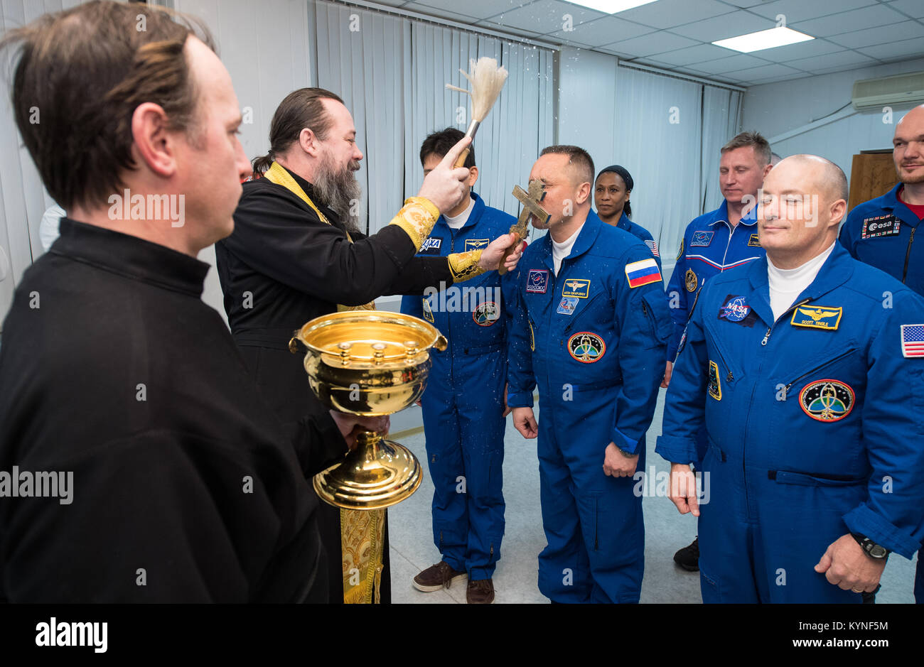 Expedition 54 Soyuz Commander Anton Shkaplerov di Roscosmos riceve la tradizionale benedizione di un sacerdote russo ortodosso al cosmonauta Hotel prima del suo lancio a bordo della Soyuz MS-07 navicelle per la Stazione Spaziale Internazionale, Domenica, Dicembre 17, 2017 di Baikonur in Kazakhstan. Shkaplerov, tecnico di volo Scott Tingle della NASA e tecnico di volo Norishige Kanai della Japan Aerospace Exploration Agency (JAXA) permetterà di trascorrere i prossimi cinque mesi di vita e di lavoro a bordo della Stazione Spaziale Internazionale. Photo credit: (NASA/Joel Kowsky) Foto Stock