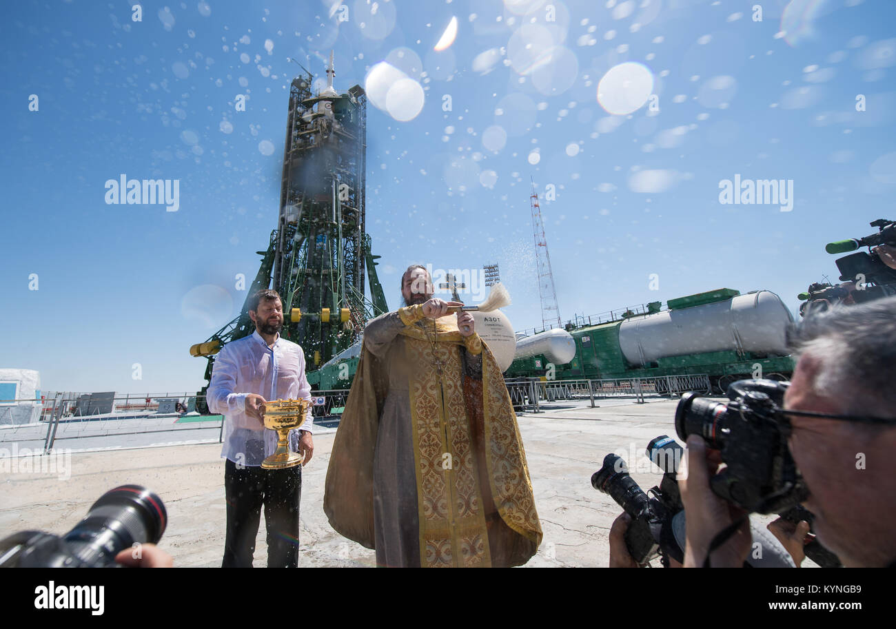 Un sacerdote ortodosso benedice i membri dei media presso il cosmodromo di Baikonur launch pad giovedì, 27 luglio 2017. Expedition 52 tecnico di volo Sergei Ryazanskiy di Roscosmos, tecnico di volo Randy Bresnik della NASA e tecnico di volo Paolo Nespoli ESA (Agenzia spaziale europea) sono in programma di lancio per la Stazione Spaziale Internazionale a bordo della navicella spaziale Soyuz dal cosmodromo di Baikonur il 28 luglio. Photo credit: (NASA/Joel Kowsky) Foto Stock