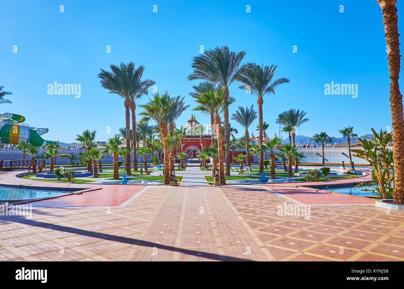 Il piccolo giardino di palme con fontane davanti all'ingresso di Alf Leila Wa Leila palace (1001 notti), Sharm El Sheikh, Egitto. Foto Stock