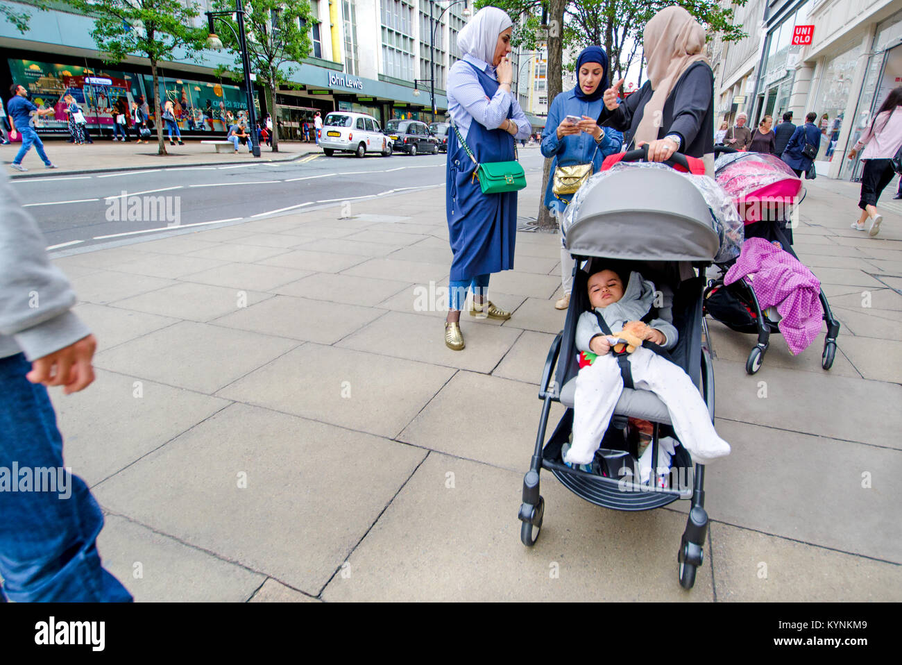 Londra, Inghilterra, Regno Unito. La famiglia musulmana con un bimbo nel passeggino Foto Stock