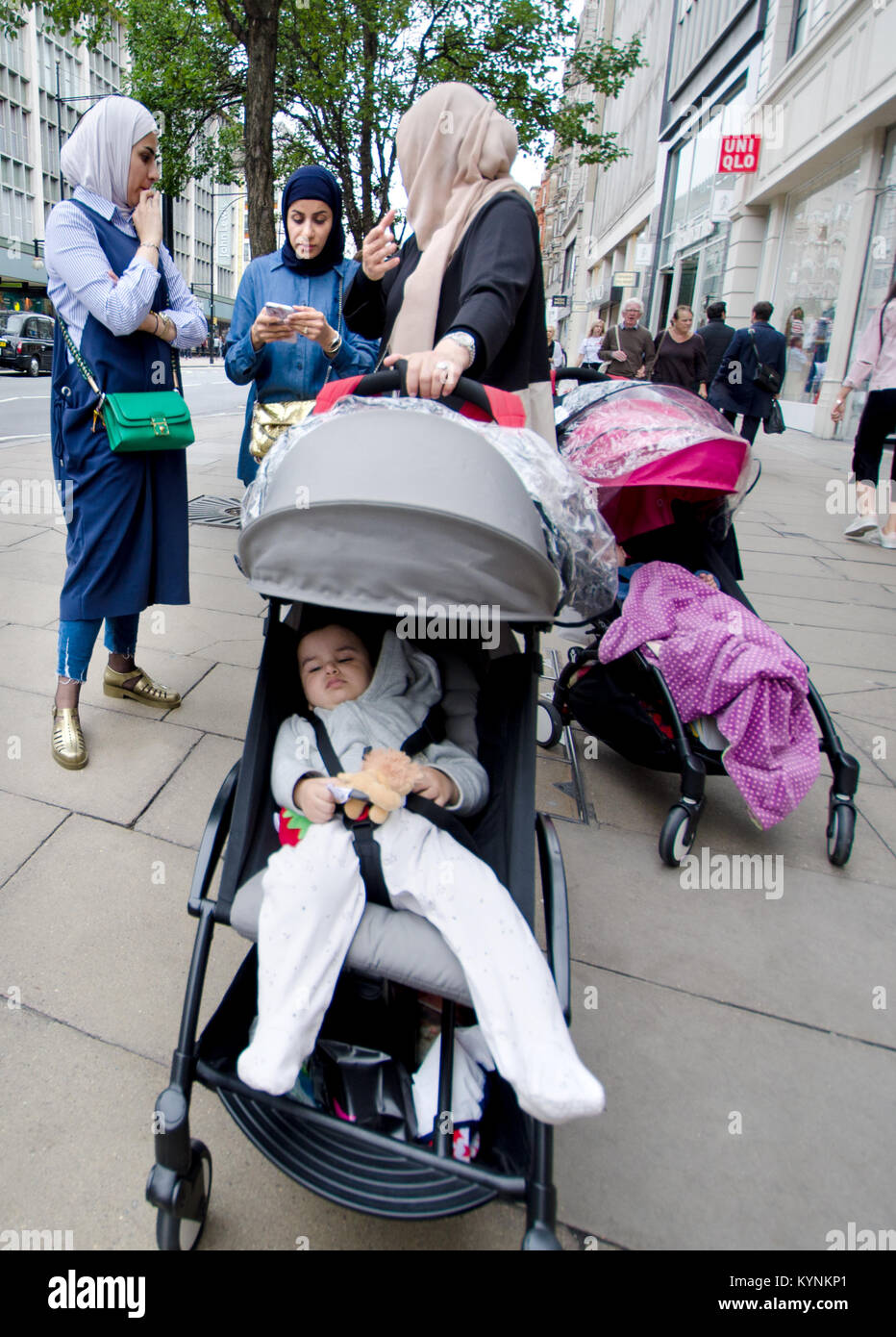 Londra, Inghilterra, Regno Unito. La famiglia musulmana con un bimbo nel passeggino Foto Stock