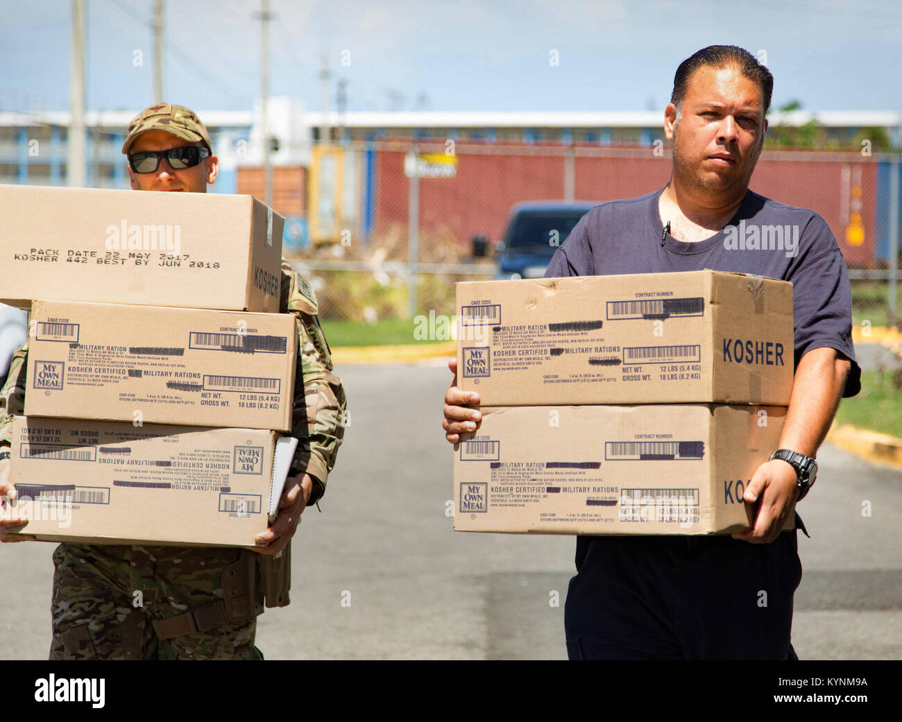 Un U.S. Pattuglia di Confine agente da Rio Grande settore e un residente locale offre cibo per i residenti di Caban, Puerto Rico, come parte del complessivo risposta federale per le conseguenze dell'Uragano Maria Ottobre 8, 2017. Stati Uniti Delle dogane e della protezione delle frontiere foto di Mani Albrecht Foto Stock