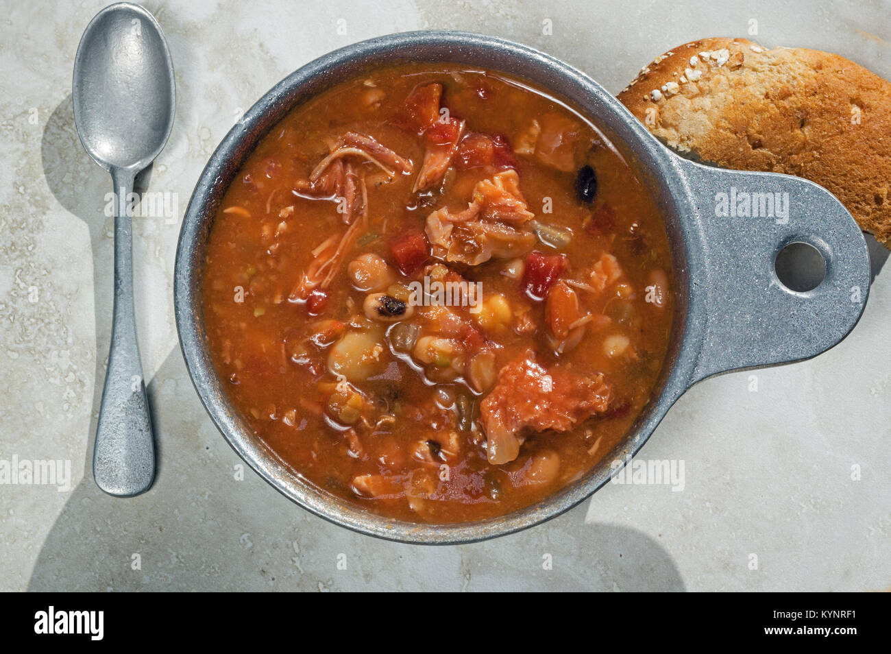 Affumicate carni di tacchino e la minestra di fagioli in metallo Soup Bowl. Si tratta di una classica zuppa ricetta e include il tacchino affumicato, pomodoro, il sedano e la cipolla. Foto Stock