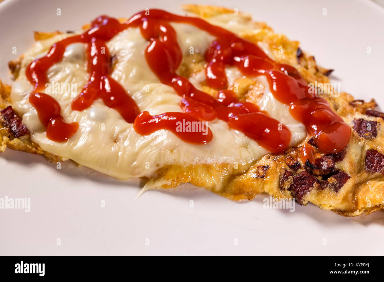 Close up di deliziosi salami salsiccia e formaggio frittata con ketchup su una piastra Foto Stock