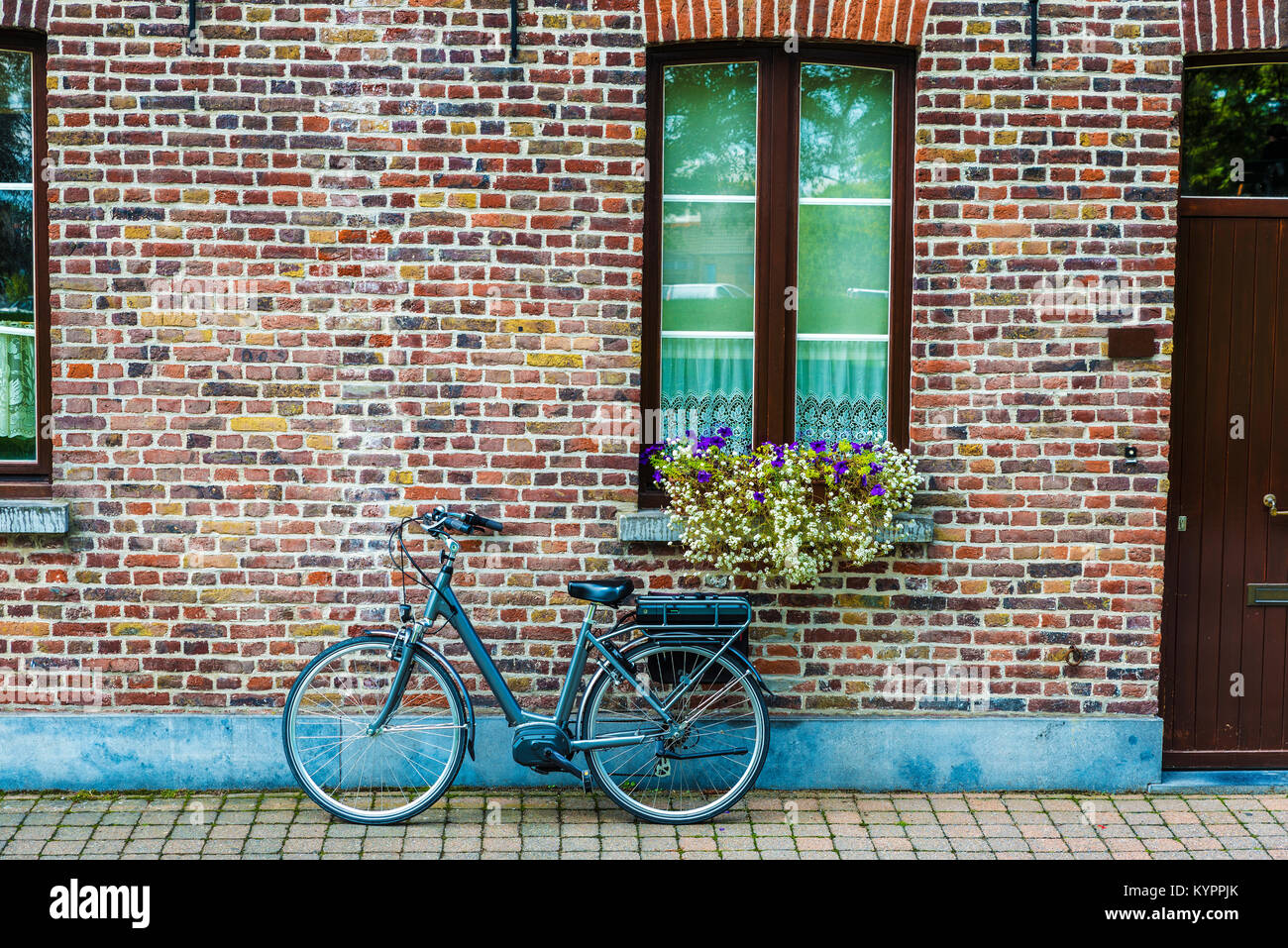 Bicicletta elettrica parcheggiata su una strada della città medievale di Bruges, Belgio Foto Stock