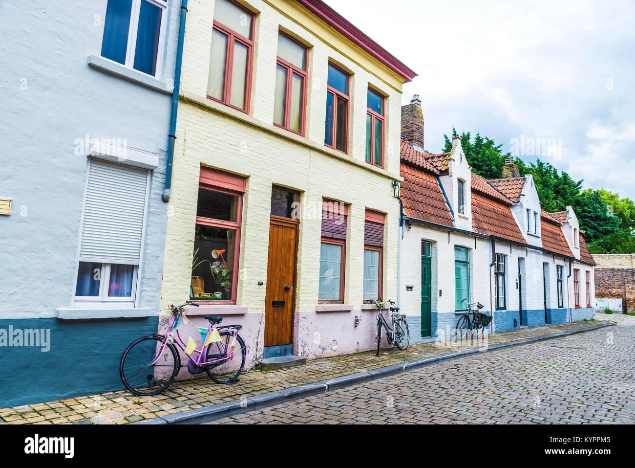 Tre biciclette parcheggiate davanti a una casa su una strada della città medievale di Bruges, Belgio Foto Stock