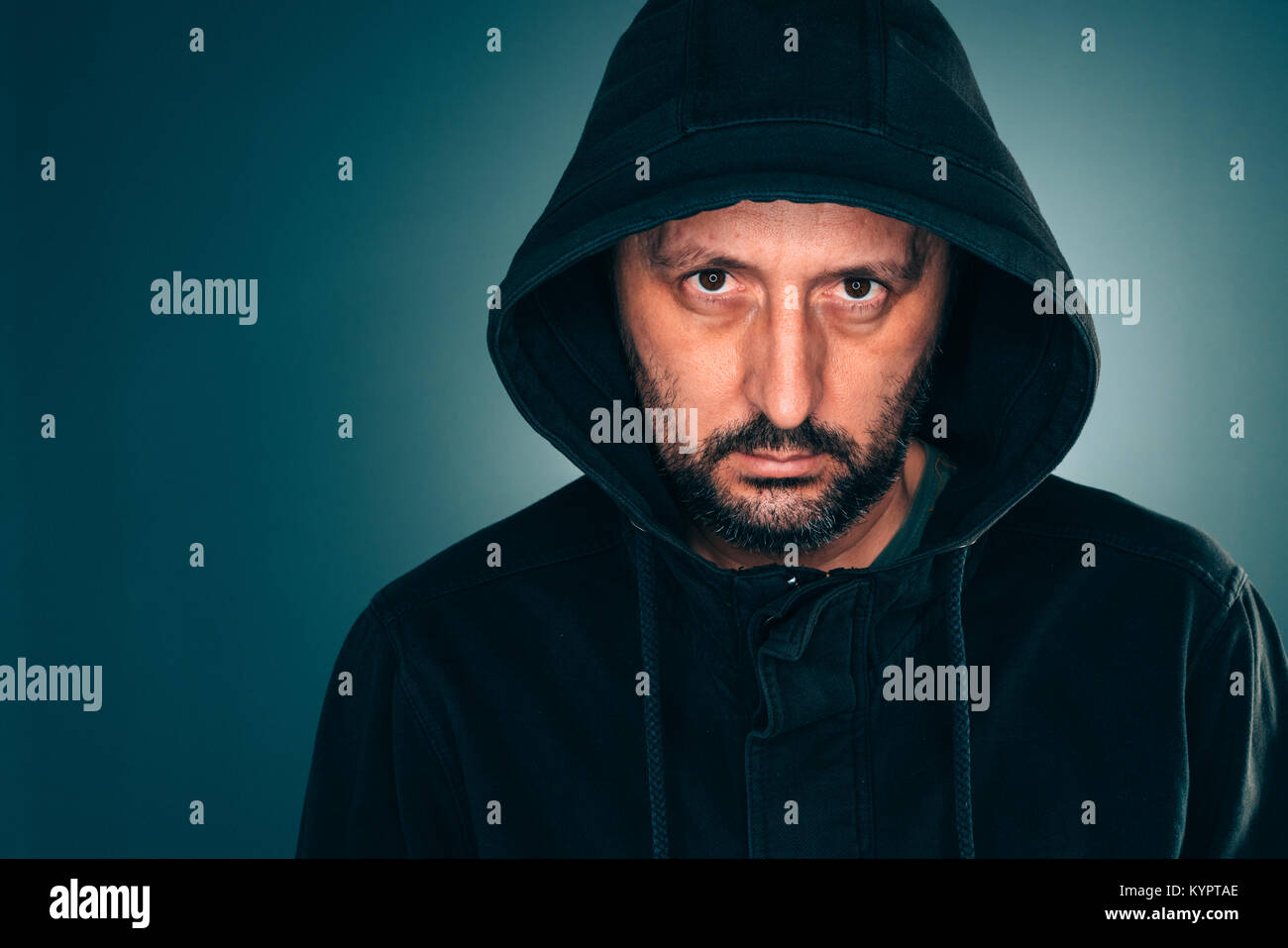 Grave ritratto di uomo adulto con hoodie guardando la fotocamera Foto Stock