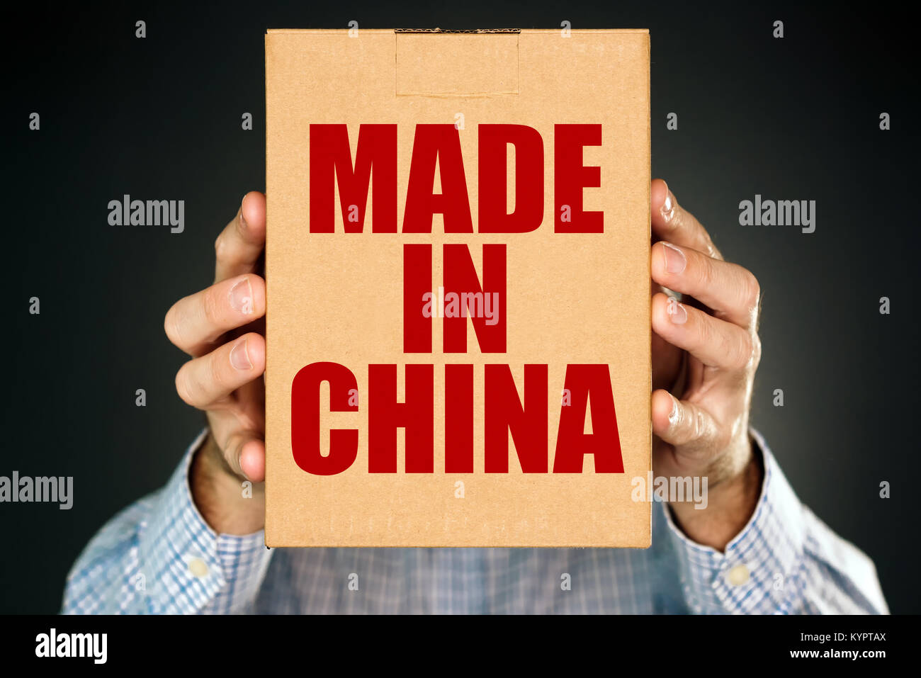 Uomo con scatola di cartone confezione del prodotto con Made in China etichetta imprint per merci merci importate dall'Asia orientale Foto Stock