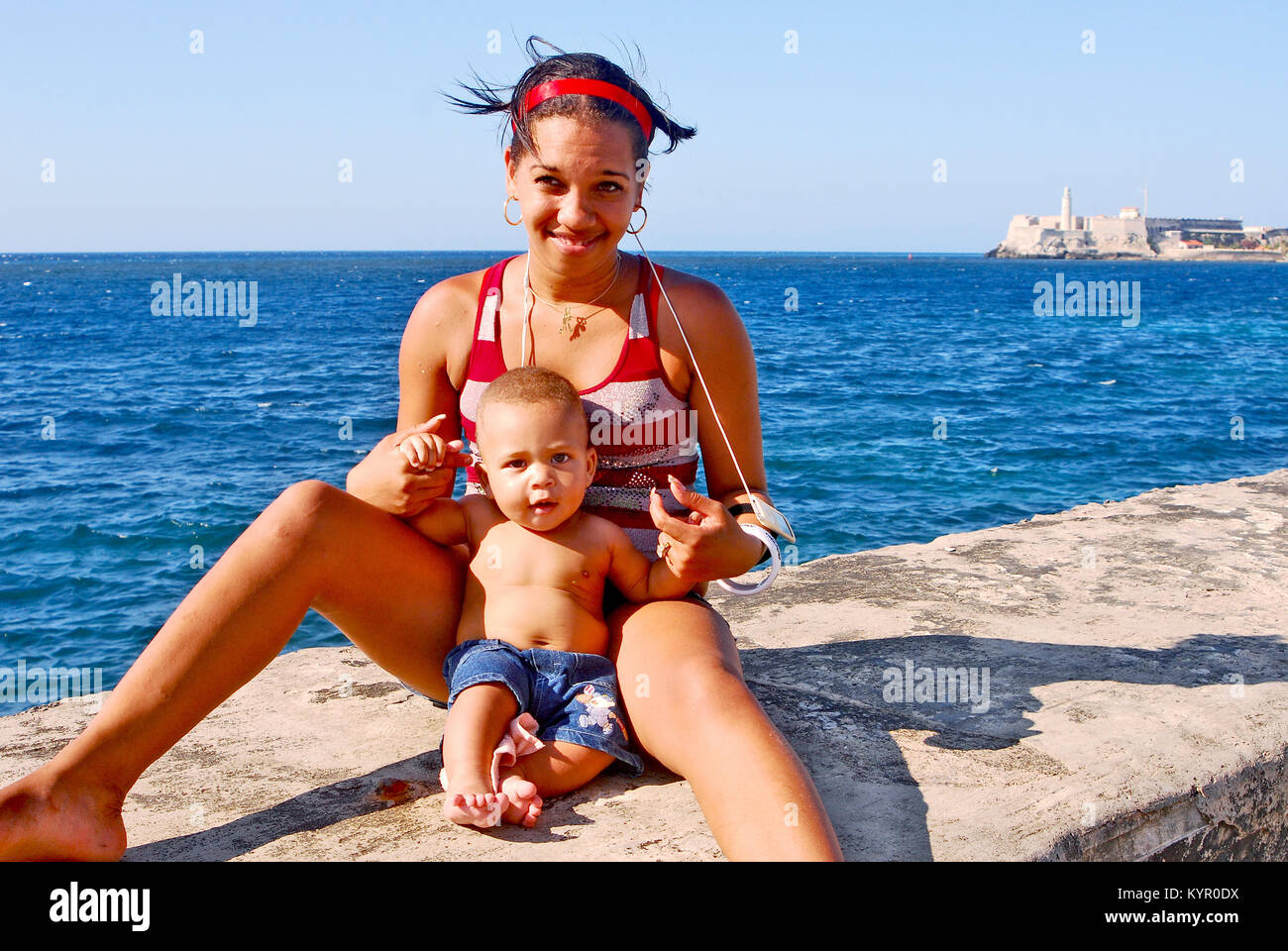L'Avana, Cuba, 11 maggio 2009. Una donna con il suo bambino seduto sul bordo della parete di Malecon beach boulevard a l'Avana, Maggio 11th, 2009. Foto Stock