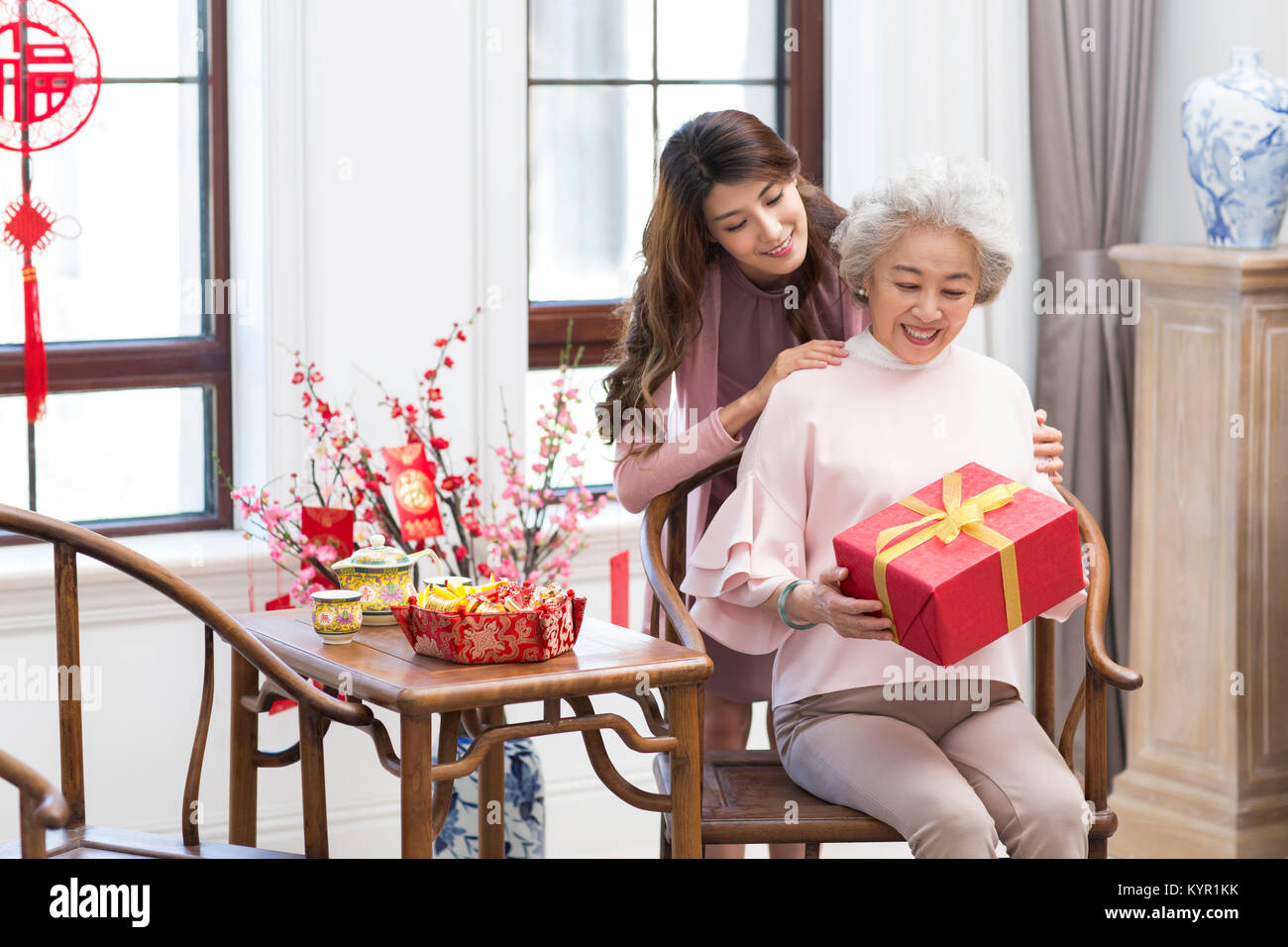 Figlia di dare dono a sua madre durante il Capodanno cinese Foto Stock