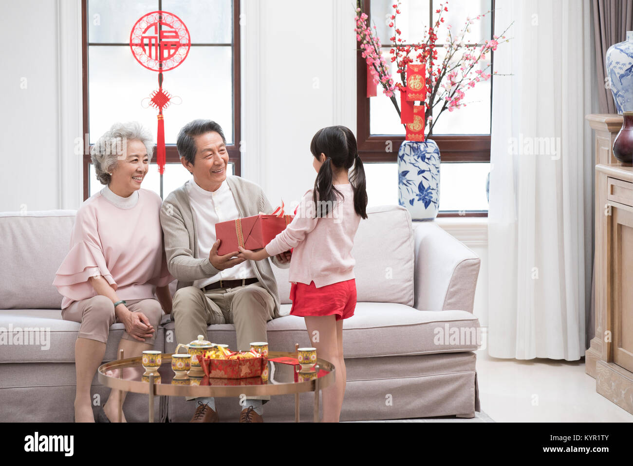 Nipote di dare dono per i nonni durante il Capodanno cinese Foto Stock