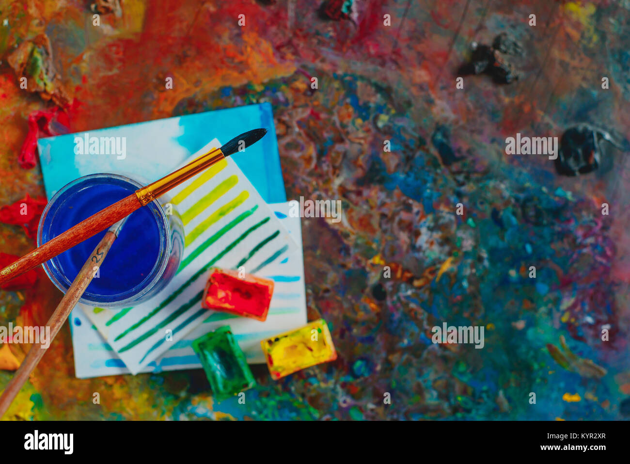 Testata con spazzole, vernici ad acquerello e schizzi. Artista strumenti su un vivace sfondo con copia spazio. Occupazione creativa del concetto. Foto Stock