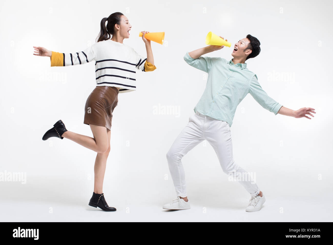 Coppia giovane grida attraverso i megafoni Foto Stock