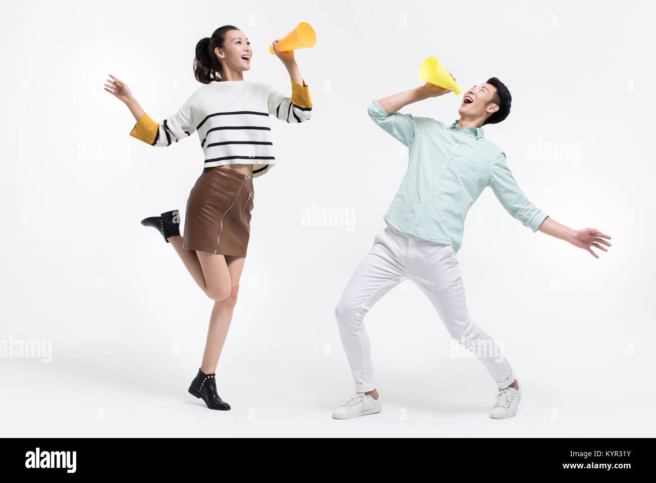 Coppia giovane grida attraverso i megafoni Foto Stock
