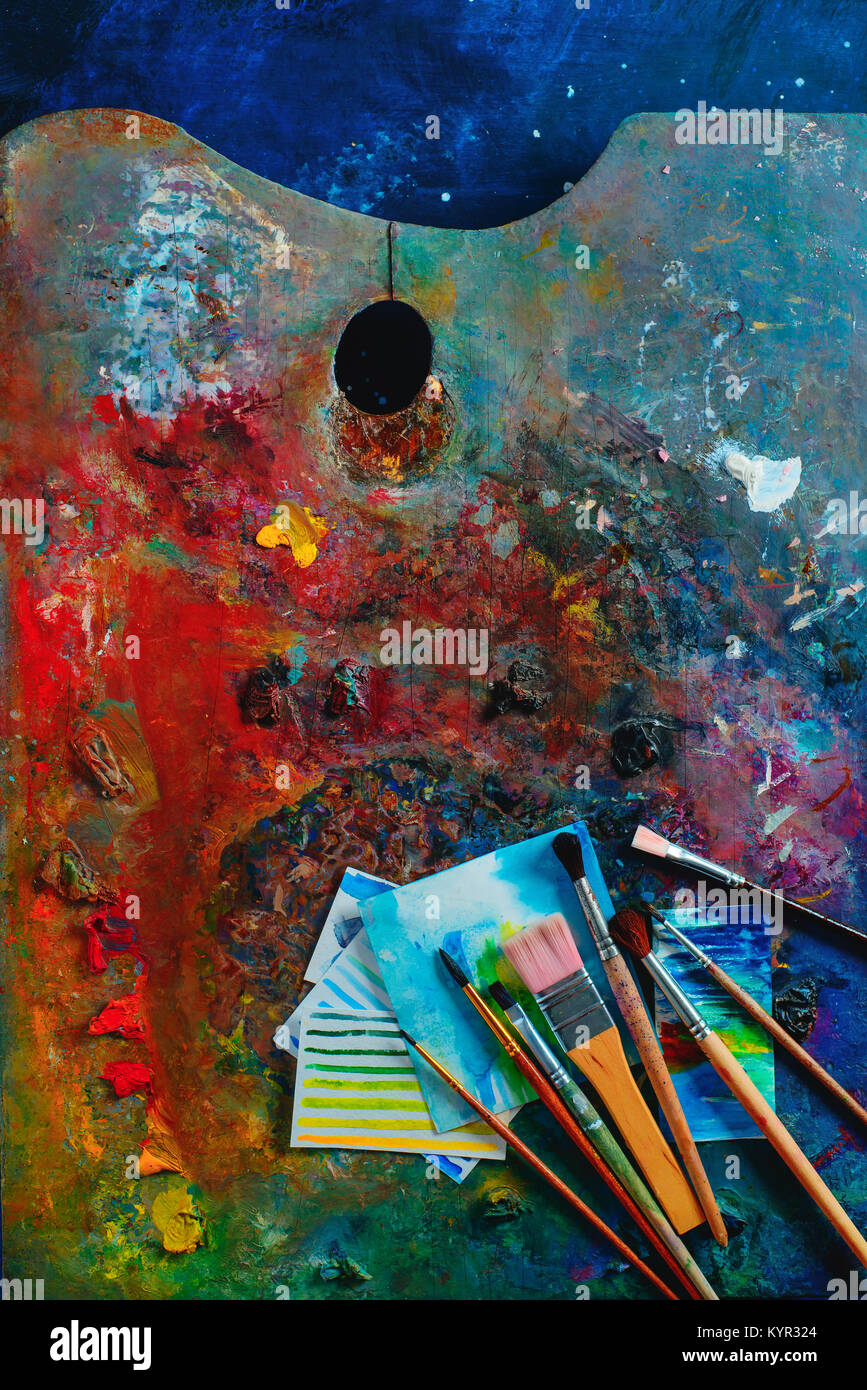 Olio colorato e acquerello tavolozza con spazzole, pitture e schizzi. Artista strumenti su uno sfondo scuro in occupazione creativa del concetto. Piatto con i laici Foto Stock