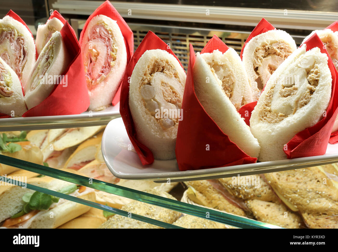 Molti panini farciti con prosciutto e carciofi e tonno con le cipolle in vendita presso il bar Foto Stock