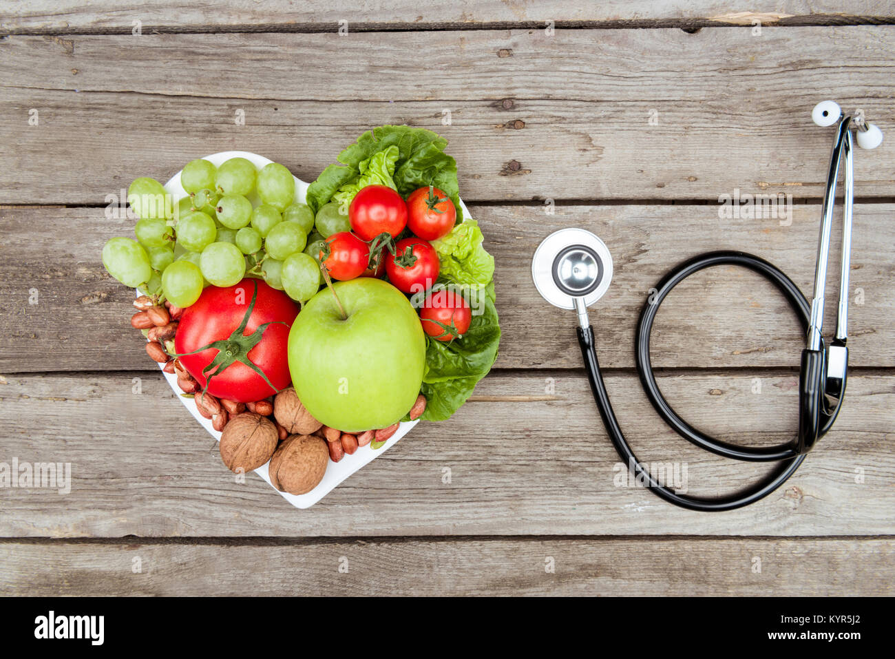 Vista dall'alto di carni varie verdure e frutta e uno stetoscopio sul tavolo di legno, mangiare sano concetto Foto Stock