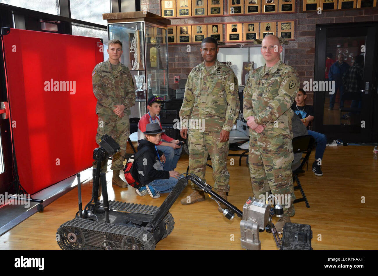 (Da sinistra) SPC. Christopher Naujoukas, un'eliminazione degli ordigni esplosivi membro del team con 764th Ordnance Company, Master Sgt. Lewin Lall, 242inesplosi operazioni del Battaglione noncommissioned officer in carica, 1 Sgt. Brian Neff, sessantaduesima Ordnance Company primo sergente, stand per la loro visualizzazione di comunemente utilizzato EOD gli strumenti e le attrezzature durante il primo Denver regionale di ingegneria di survoltaggio, la scienza e la tecnologia (BEST) campionato di robotica, Dec. 16-17, 2017, presso il Campus Auraria Eventi Centro, Metropolitan State University. (U.S. Esercito Foto Stock