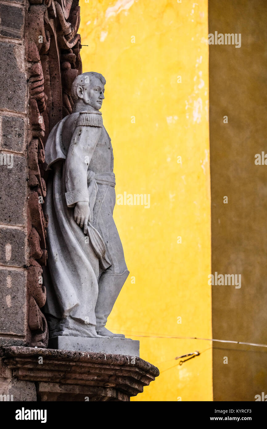 Una scultura in marmo contro di colore giallo brillante chiesa parete n San Miguel De Allende,Messico Foto Stock