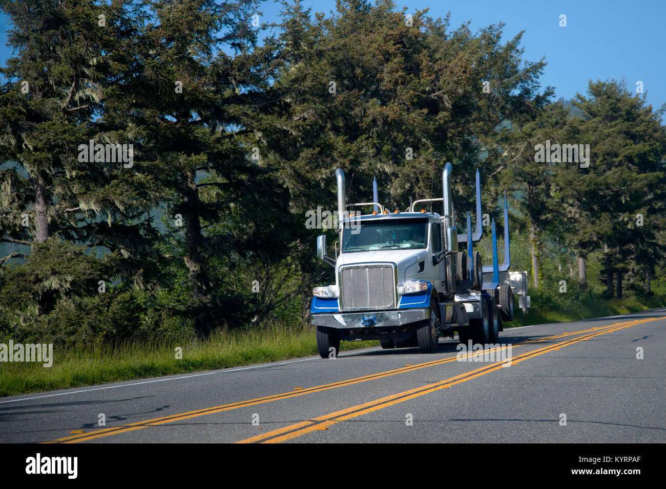 Un grande e potente commerciale semi blu carrello trasporta due parti di rimorchi con barre di guida e semi-assi fissi al telaio per i registri di trasporto Foto Stock