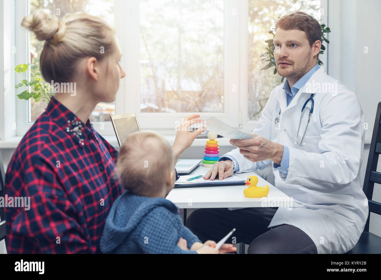 Pediatra dà una prescrizione per la madre dopo la consultazione Foto Stock