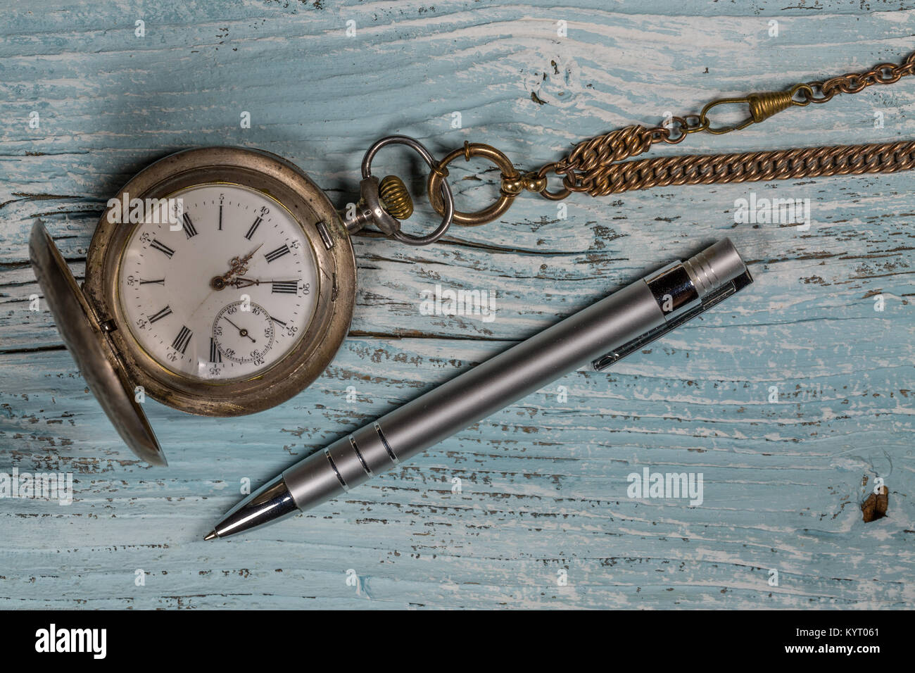 Argento vecchio orologio da tasca e penna su un tavolo di legno Foto Stock