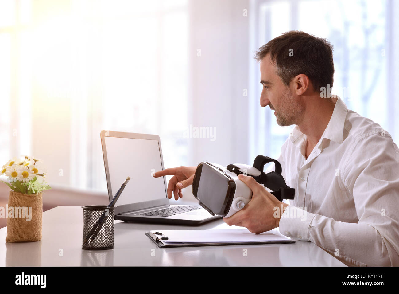 Lavoratore di ufficio lavora con occhiali per realtà virtuale e il computer in ufficio. Composizione orizzontale. Foto Stock