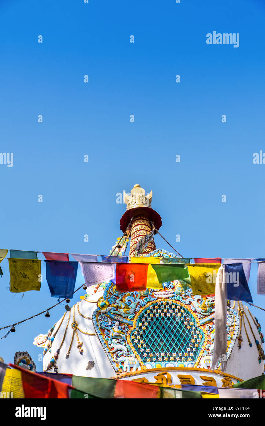 Sculture decorative e di preghiera bandiere sul tetto del Tibetano tempio buddista con il blu del cielo Foto Stock