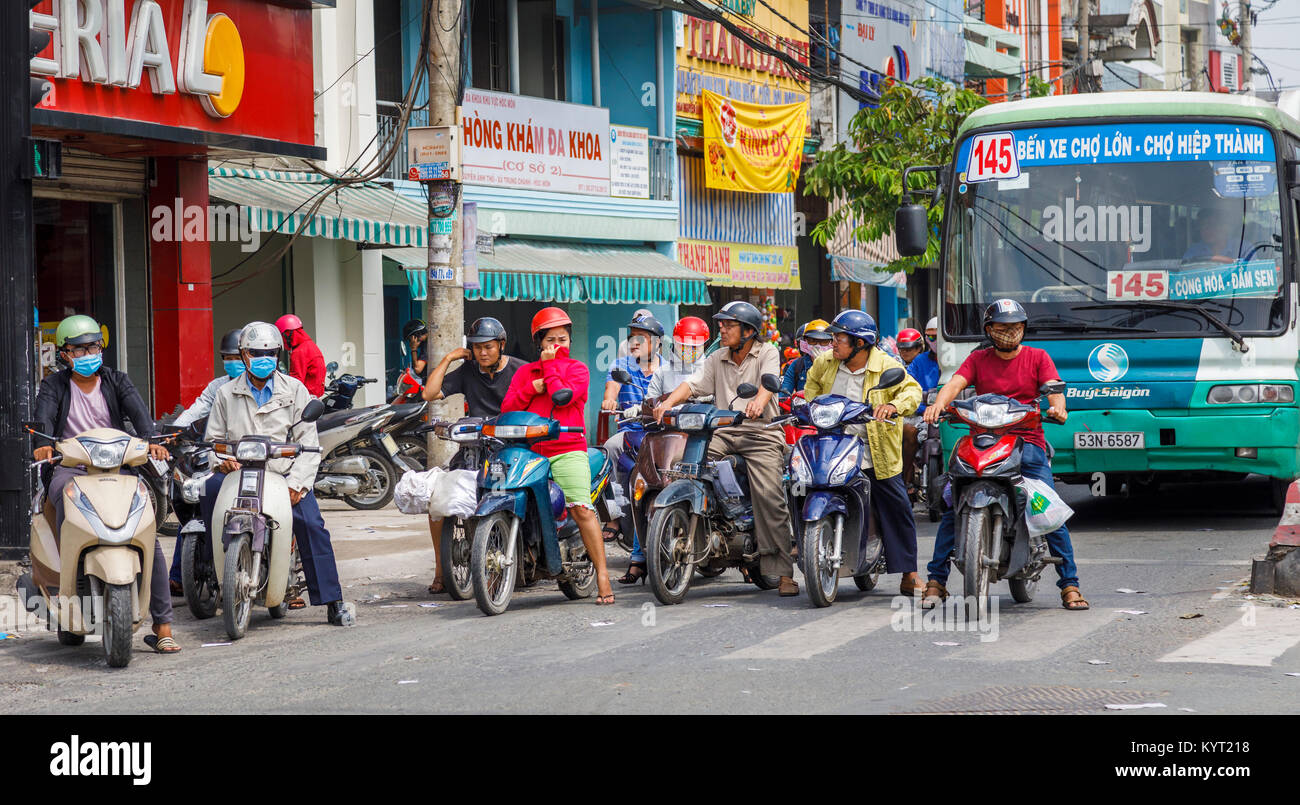 Locale stile di vita vietnamita: tipico affollata strada in vista (Saigon Ho Chi Minh City), il sud del Vietnam con molte moto e piloti in traffico di occupato Foto Stock