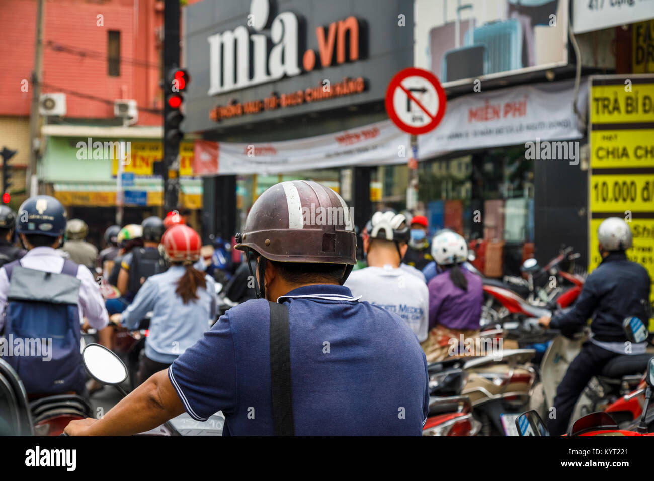 Lo stile di vita locale: vista posteriore del casco di uno dei molti motociclisti, tipica del traffico street view di Saigon (Ho Chi Minh City), il sud del Vietnam Foto Stock