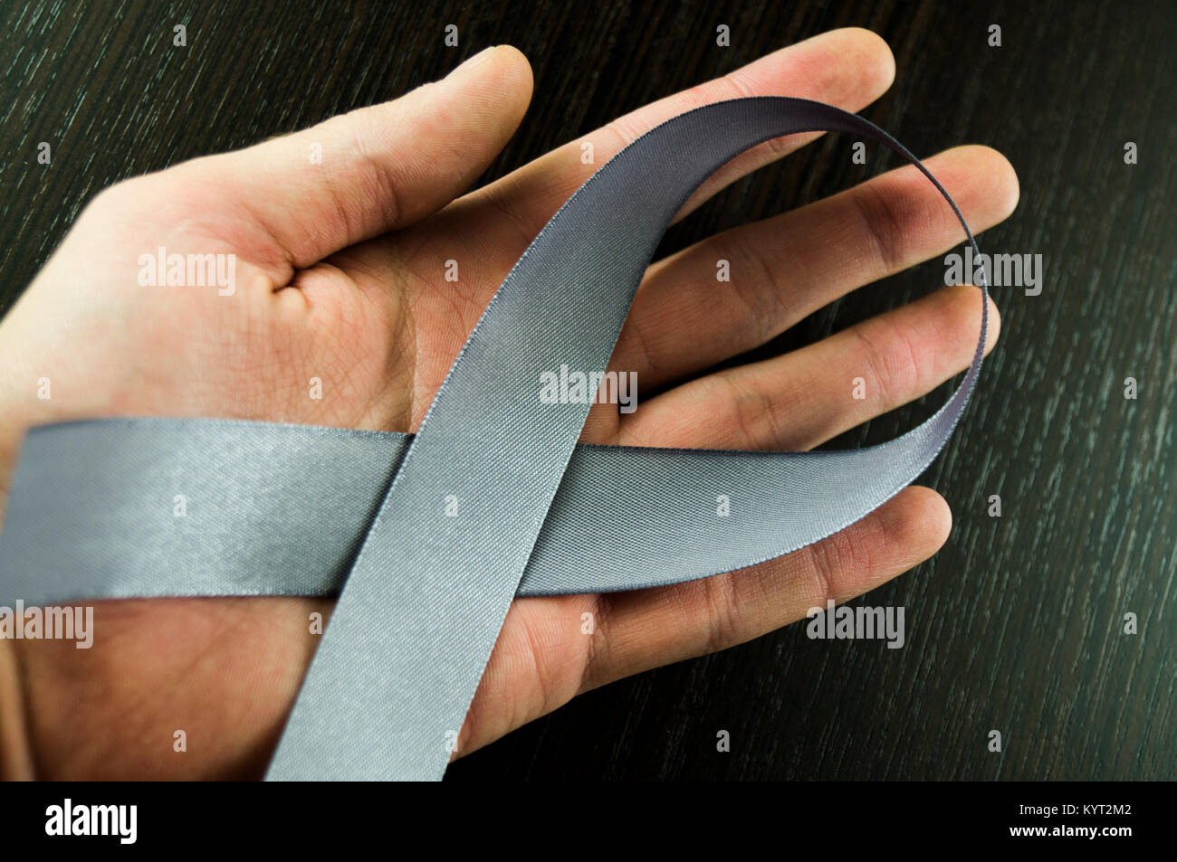 Il morbo di Parkinson giorno gli uomini la mano con nastro grigio sfondo Foto Stock