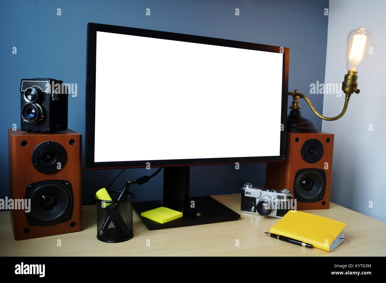 Area di lavoro elegante con monitor, vintage fotocamera e lampada e delle forniture per ufficio. Mock-up. Foto Stock