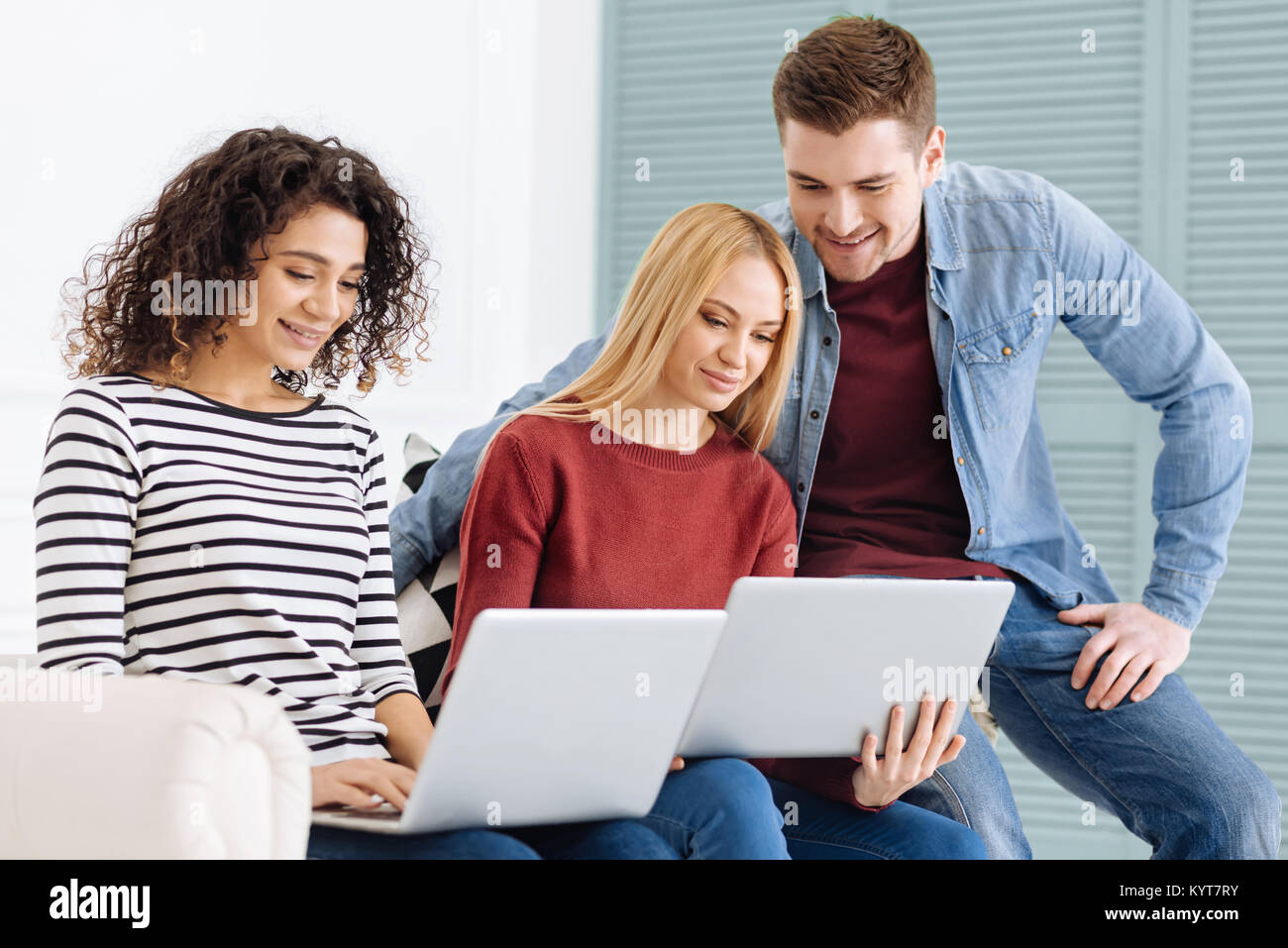 Positivo felicissimi giovani guardando i computer Foto Stock