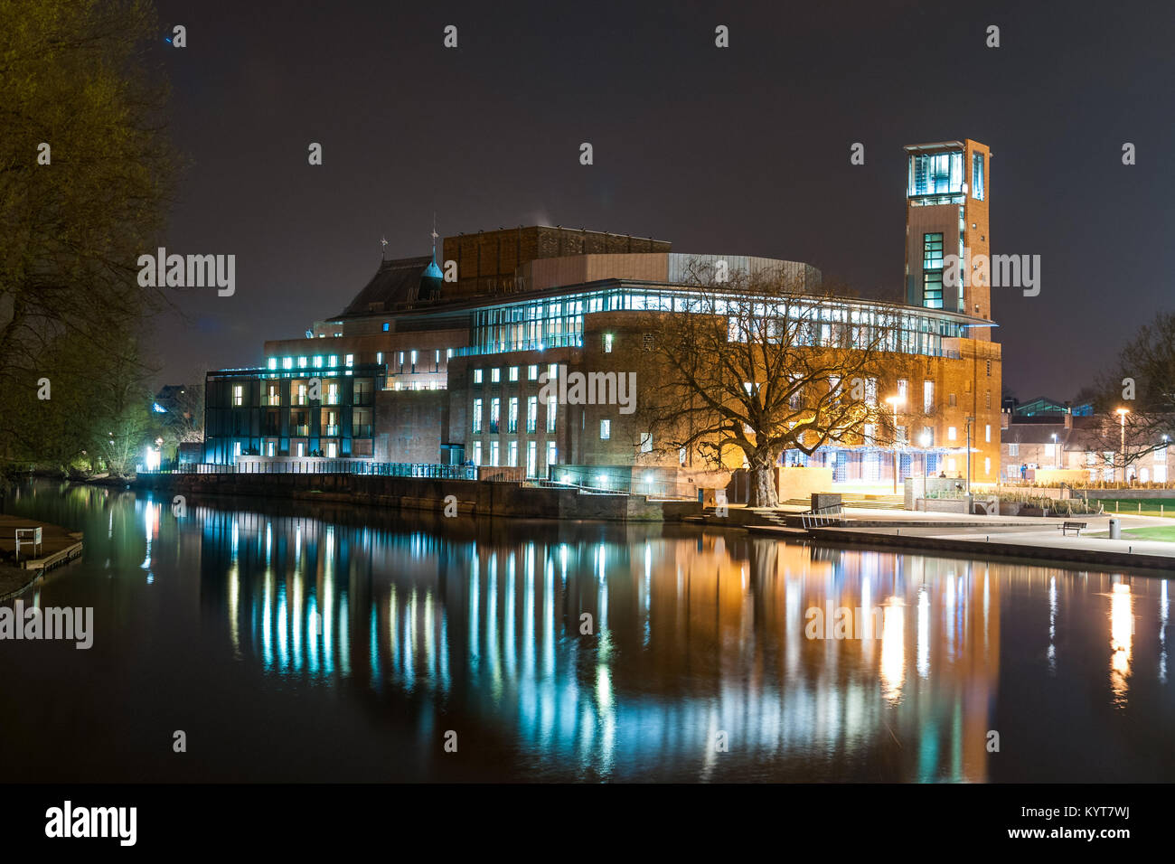 Il Royal Shakespeare Company teatro esterno dell'edificio di notte con la riflessione nel fiume Avon, Stratford-upon-Avon, Warwickshire, Regno Unito Foto Stock