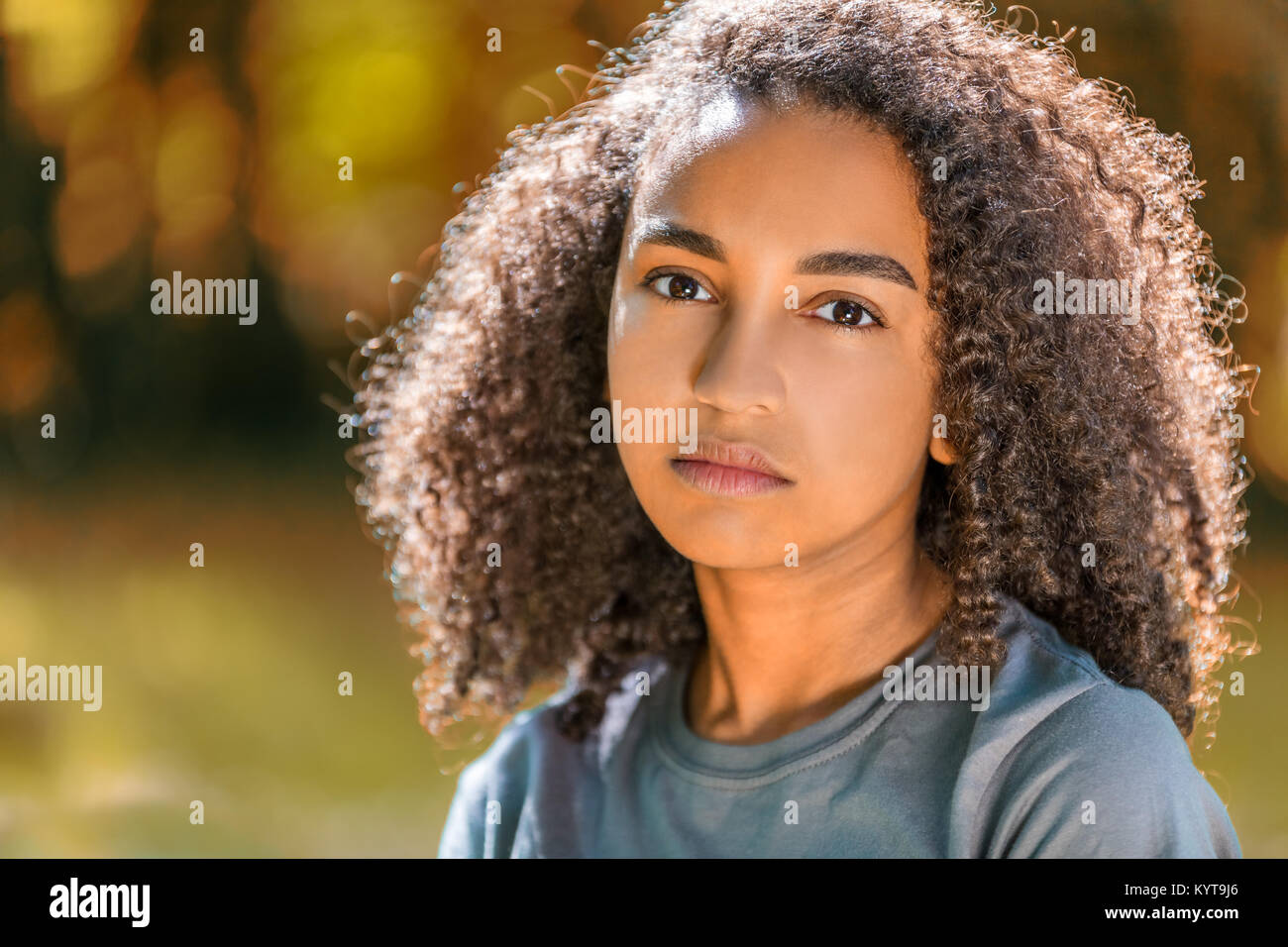 Bellissima gara di misto americano africano ragazza adolescente femmina giovane donna fuori in autunno o in autunno guardando triste premuto o riflessivo Foto Stock
