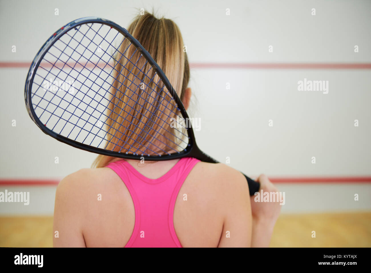 Vista posteriore di squash o giocatore di tennis con la racchetta Foto Stock