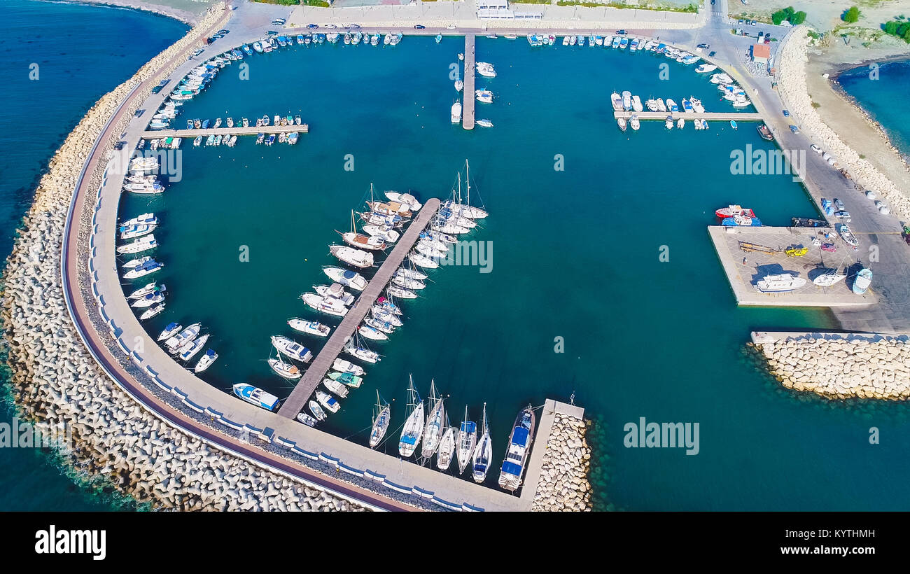 Antenna ad occhio d'uccello del Zygi villaggio di pescatori porto, Larnaca, Cipro. Il pesce barche ormeggiate nel porto di yacht ancorati e sullo skyline della città Foto Stock