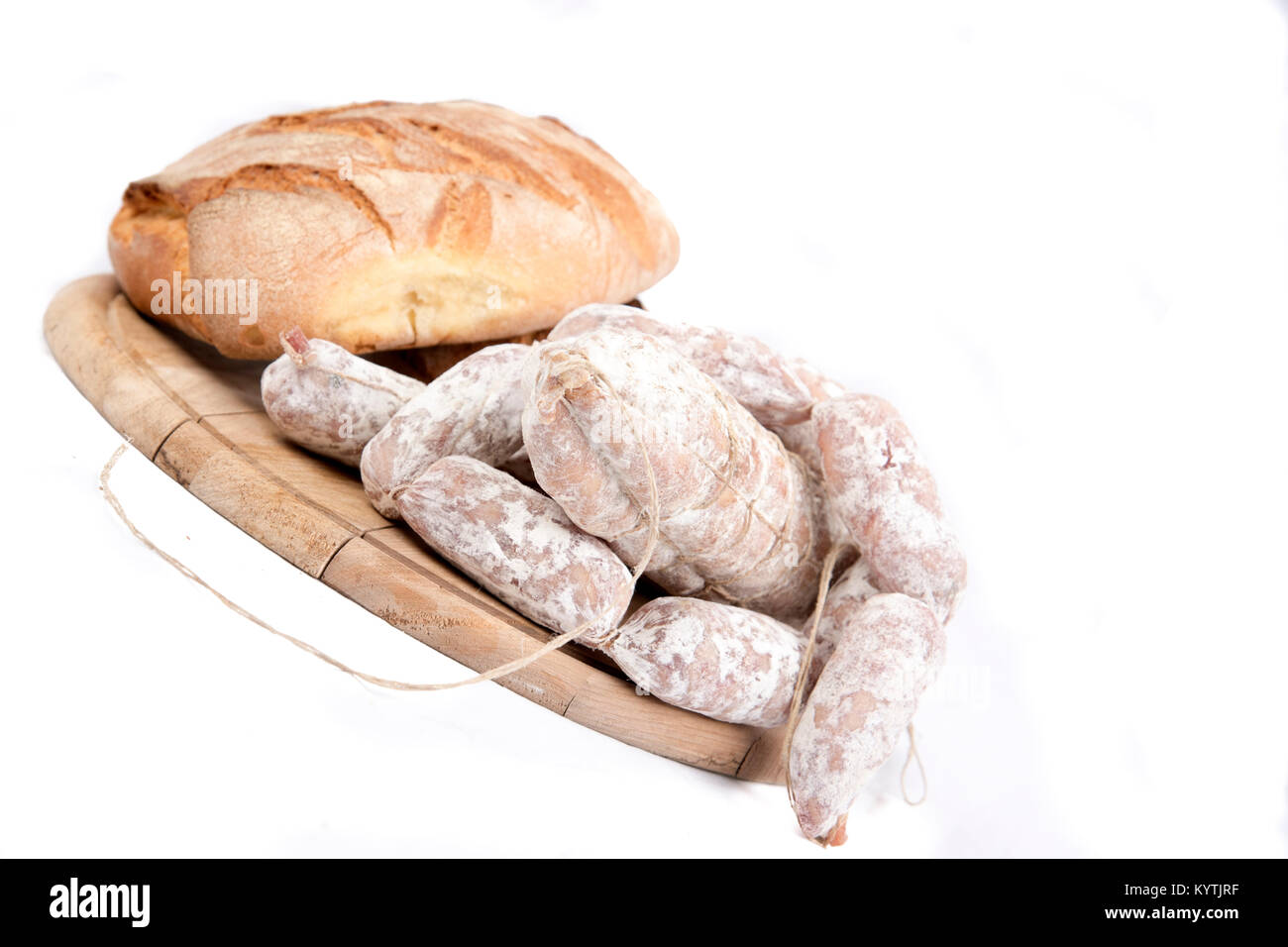 Link salsicce con la pagnotta di pane fresco sul tagliere di legno isolato su bianco con copia spazio. Foto Stock