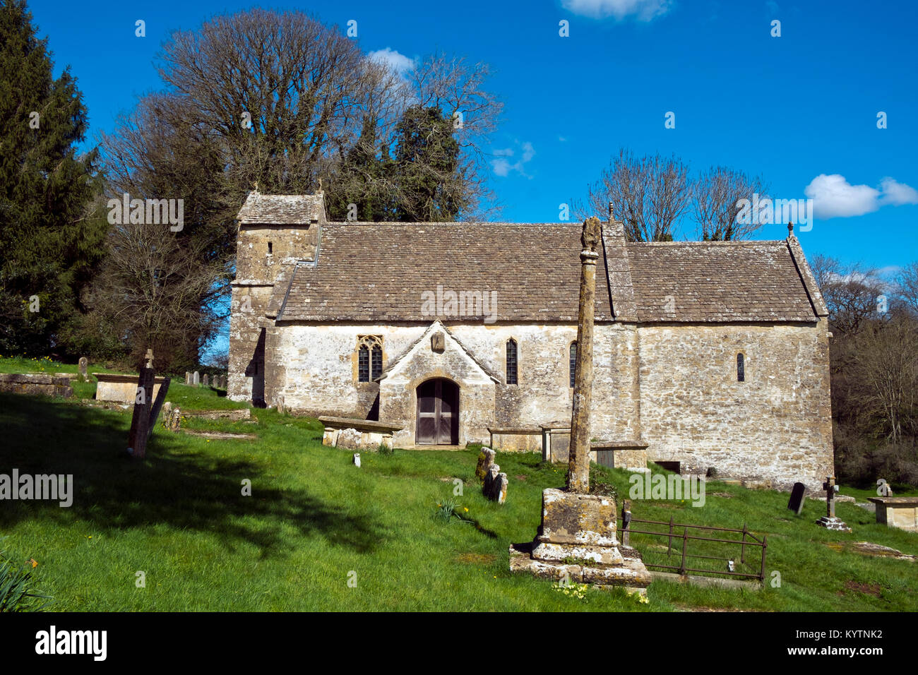 Sole primaverile sulla pittoresca vecchia chiesa a Duntisbourne Rouse in Cotswolds, Gloucestershire, Regno Unito Foto Stock