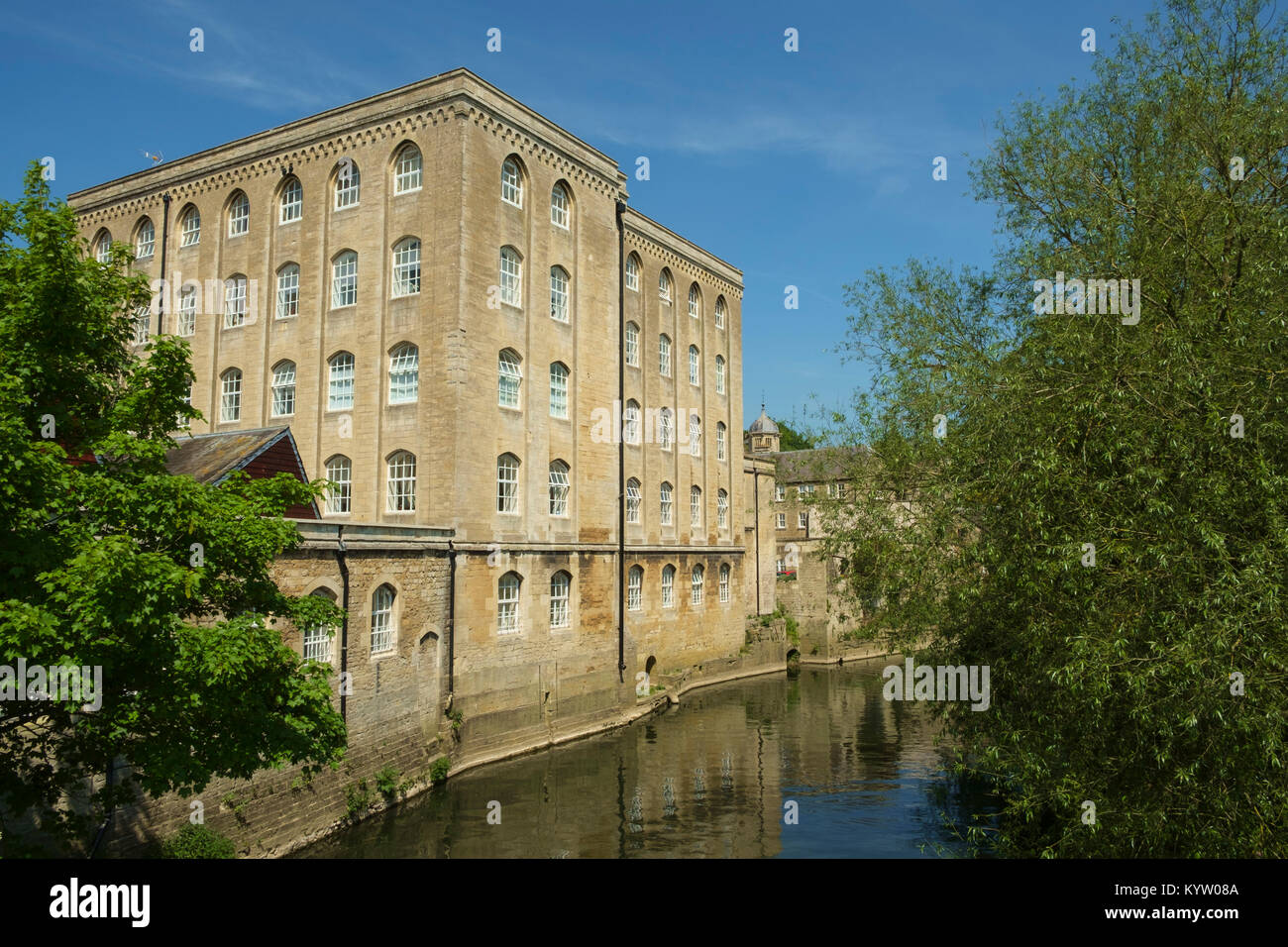Pittoresca vecchia architettura industriale lungo il fiume Avon nel sole primaverile, Bradford on Avon, Wiltshire, Regno Unito Foto Stock
