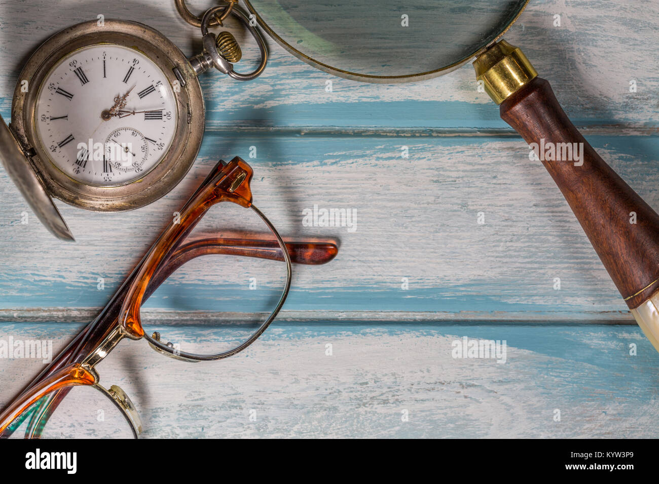 Occhiali,pen,argento orologio da tasca e lente di ingrandimento su legno  Foto stock - Alamy